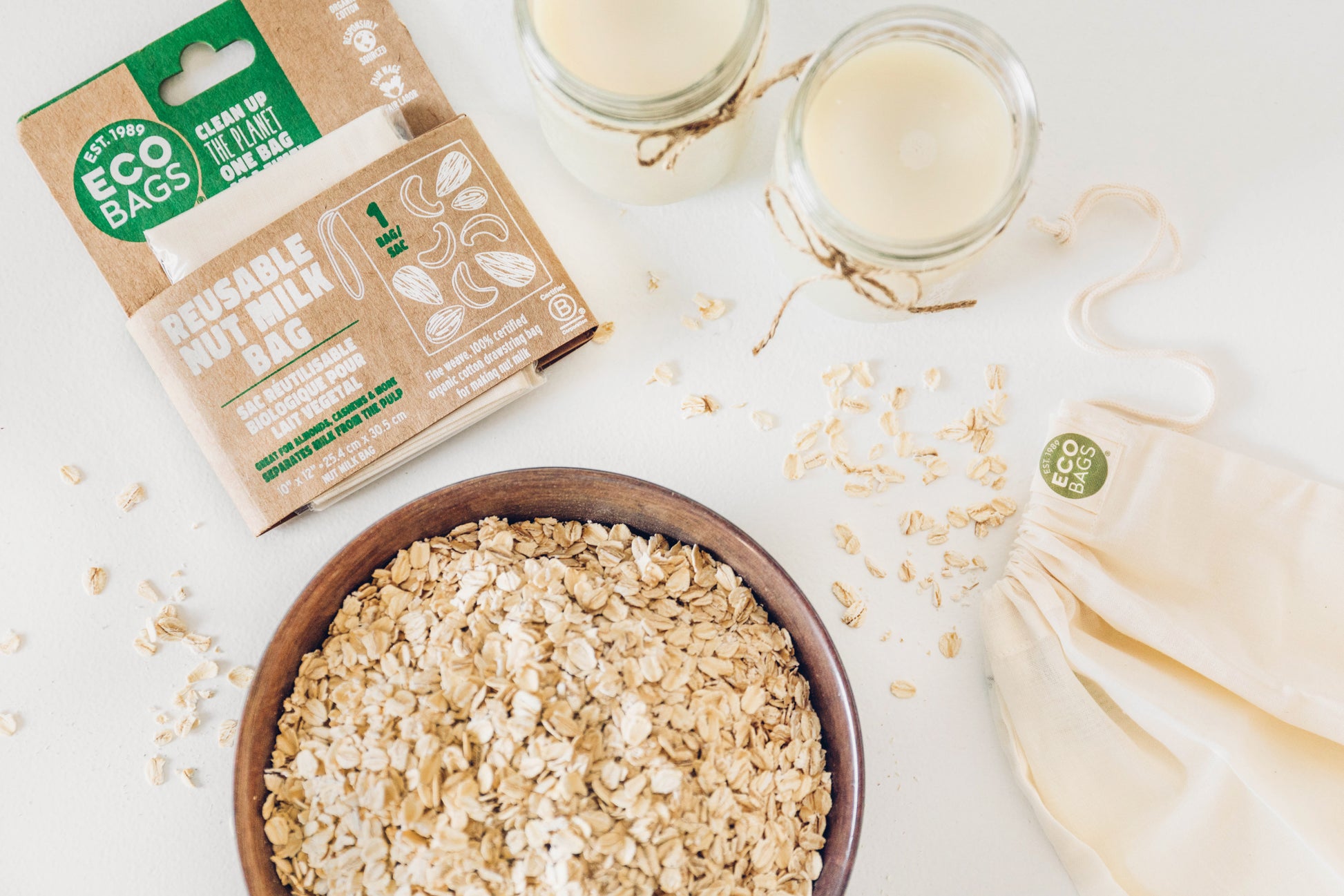 Oats in a bowl with eco-friendly packaging and bags on a white background