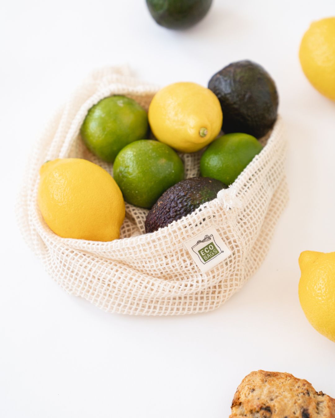 Mesh produce bag with fruits on a white background