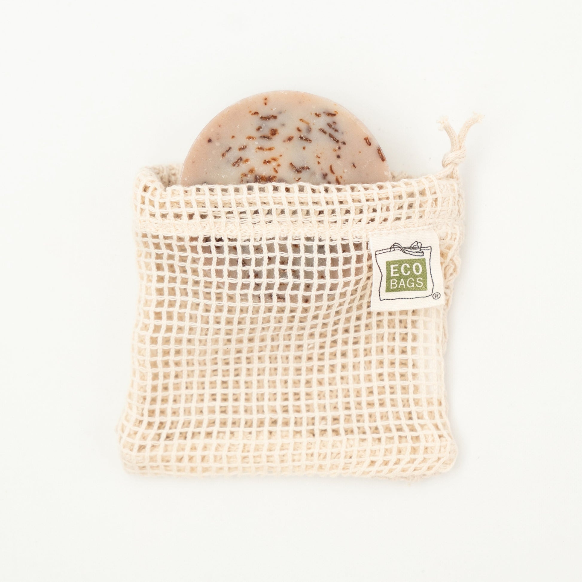 A natural colored organic cotton soap saver bag with an open mesh design, featuring a tag that reads 'ECOBAGS'.
