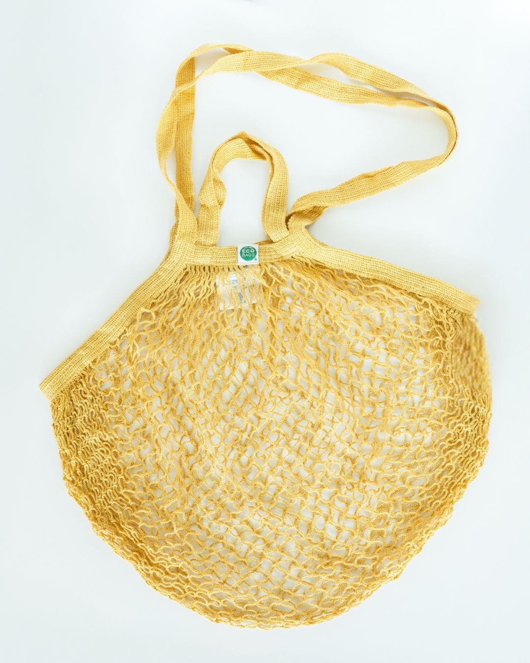 Yellow mesh string bag on a white background