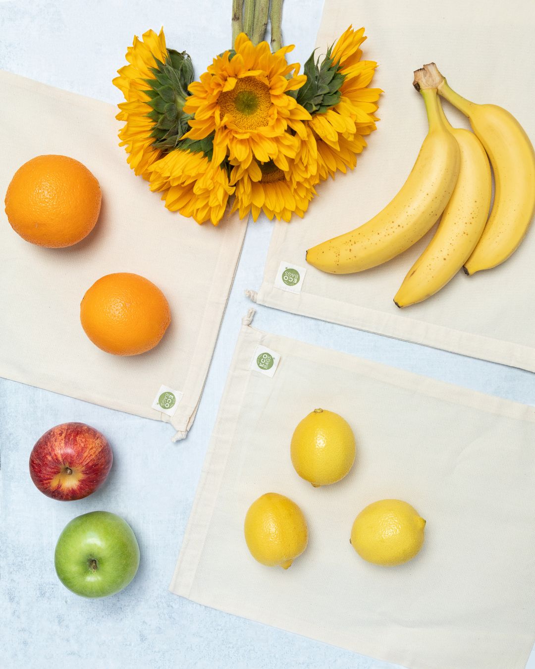 Reusable produce bags with fruits and flowers on a light background